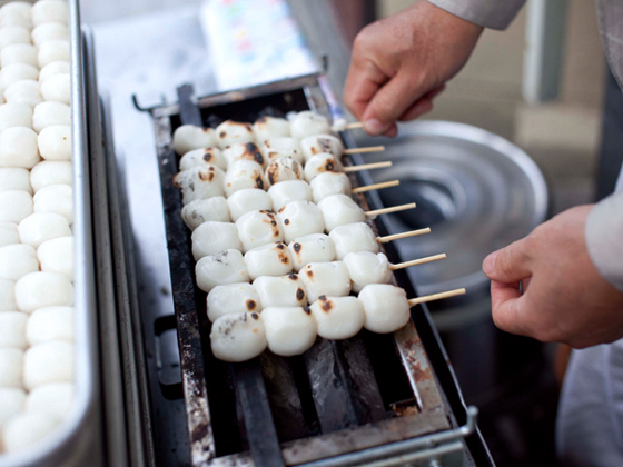 大粒4個に琥珀色のタレがかかった焼だんご1本100円。地元民の大好物！
