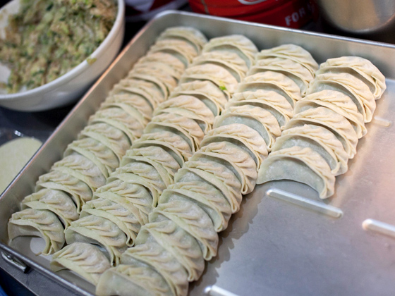くるくるくるとあっという間に包んでしまう餃子も名物。サイドメニュー筆頭でオーダーを。