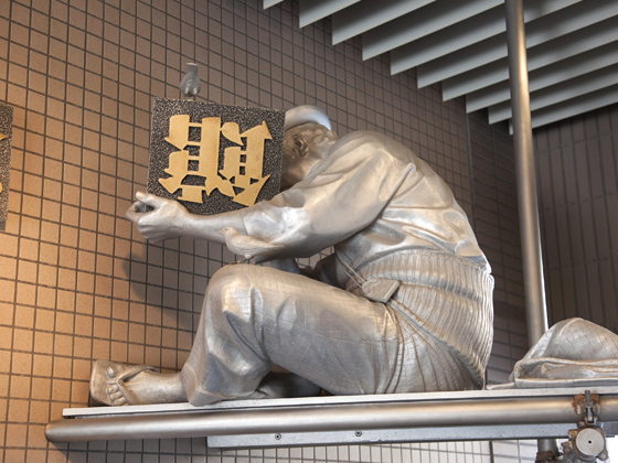 エントランスには、記念館の看板を取り付けている寅さんが。漢字が苦手なため上下がわからず思案中。